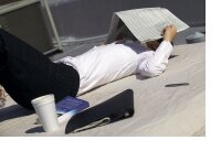 photo of woman with a newspaper covering her head